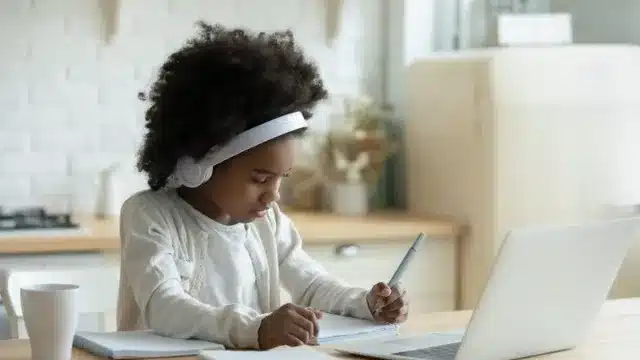 Niña estudiando con ordenador – control de miopía infantil